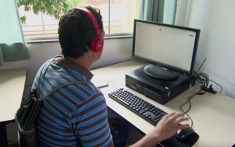 Estudante utilizando computador na biblioteca do Itapoã (Foto: Reprodução/TV Globo)