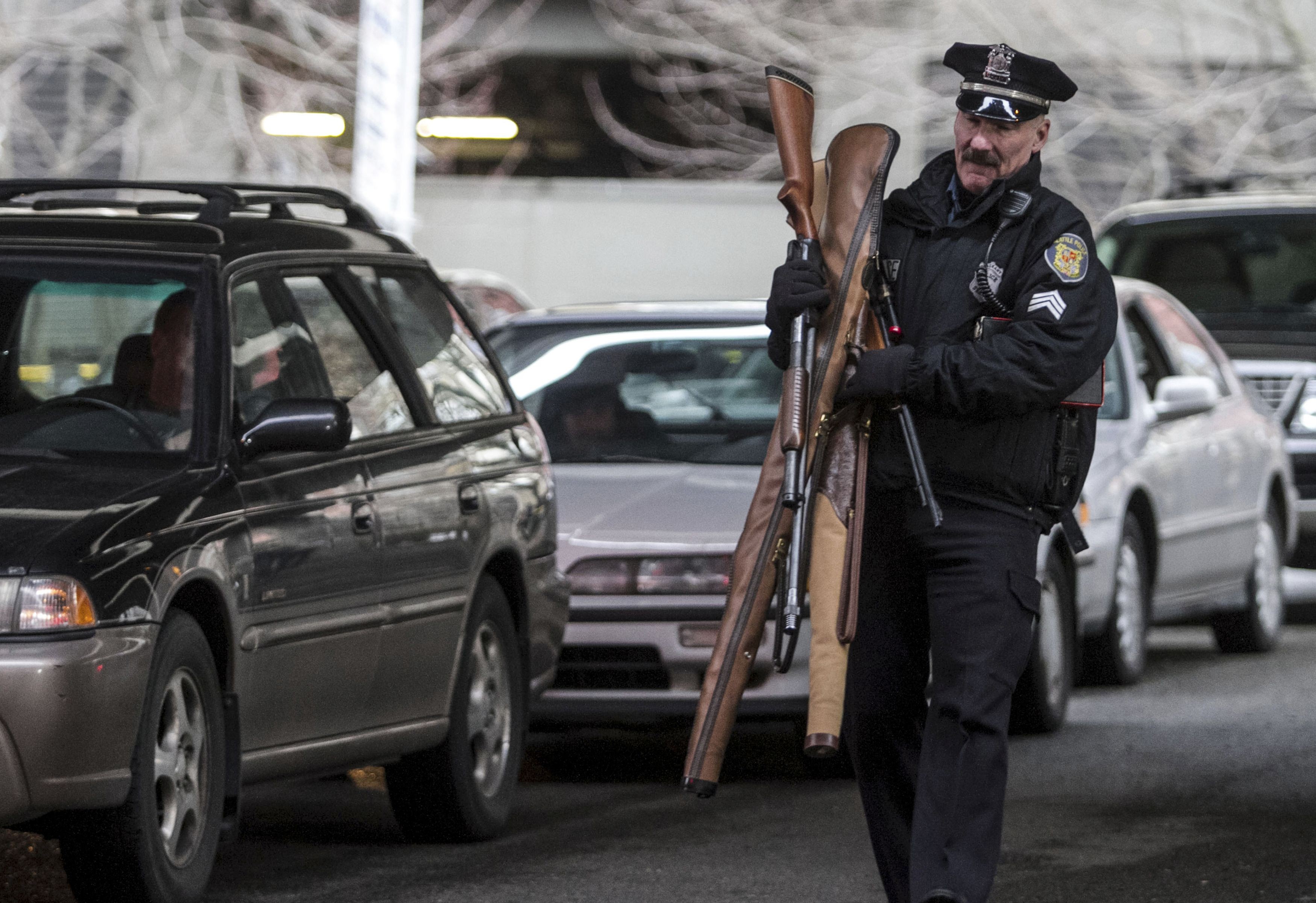 Policial de Seattle carrega armas trocadas por vale-presente (Foto: REUTERS)