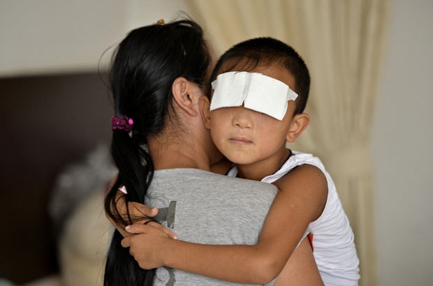 O garoto com a mãe nesta quarta-feira (4) em Taiyuan, província chinesa de Shanxi (Foto: Reuters)