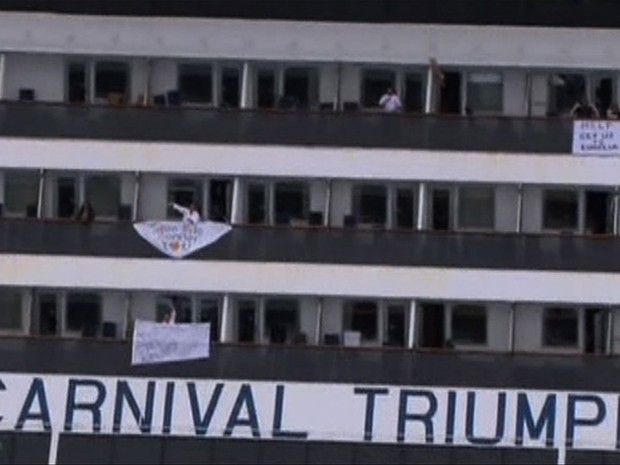 Passageiros estendem faixas com mensagens à beira das varandas de suítes do cruzeiro (Foto: Reuters/NBC News)