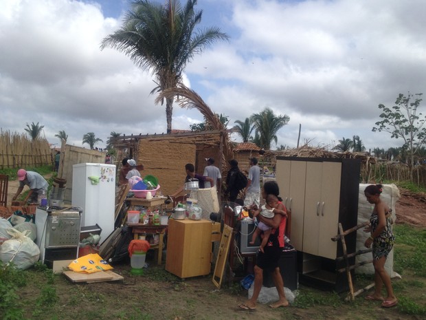 Famílias retiram os pertences de dentro das casas.   (Foto: Gil Oliveira/G1)