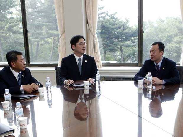 Funcionários sul-coreanos conversam em Seul antes antes da viagem da delegação para conversar com a Coreia do Norte (Foto: Lee Jae-Won/ AP)
