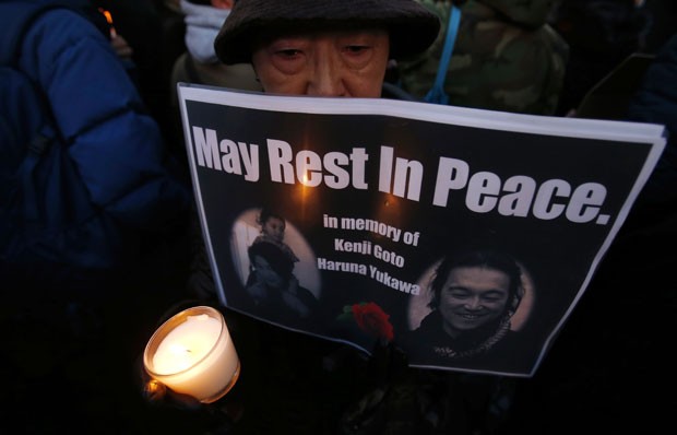  Mulher segura cartaz com a frase â€œque descansem em pazâ€ em vigÃ­lia para os refÃ©ns japoneses Kenji Goto e Haruna Yukawa, mortos pelo Estado IslÃ¢mico, neste domingo (8) em TÃ³quio (Foto: Yuya Shino/Reuters)
