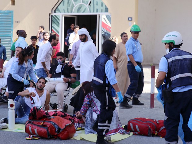 Equipe de resgate ajuda a socorrer moradores que inalaram fumaça durante incêndio em um prédio em Sharjah, nos Emirados Árabes Unidos, na quinta (1º) (Foto: AP Photo)