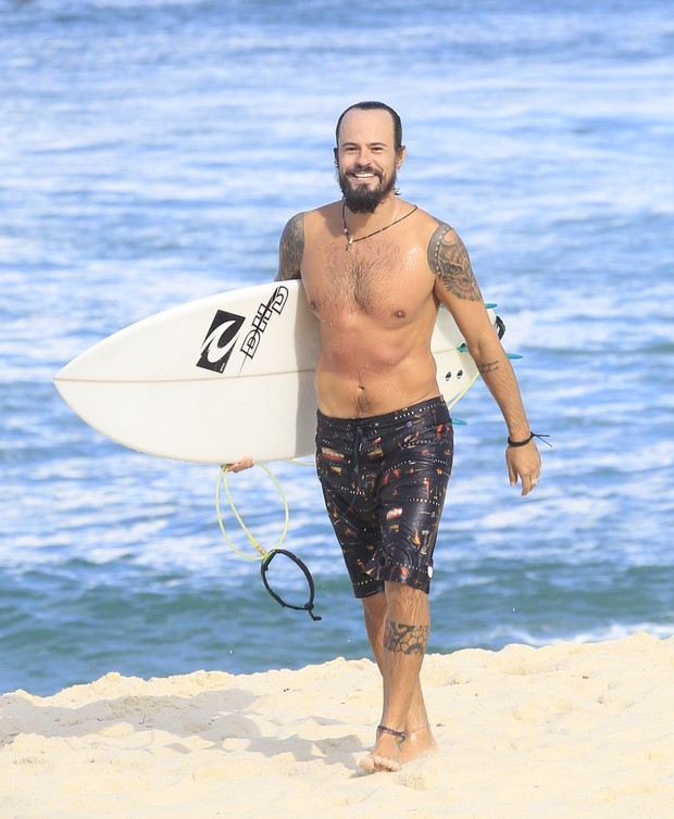 EGO Paulinho Vilhena sai sorridente do mar após surfar notícias de Praia