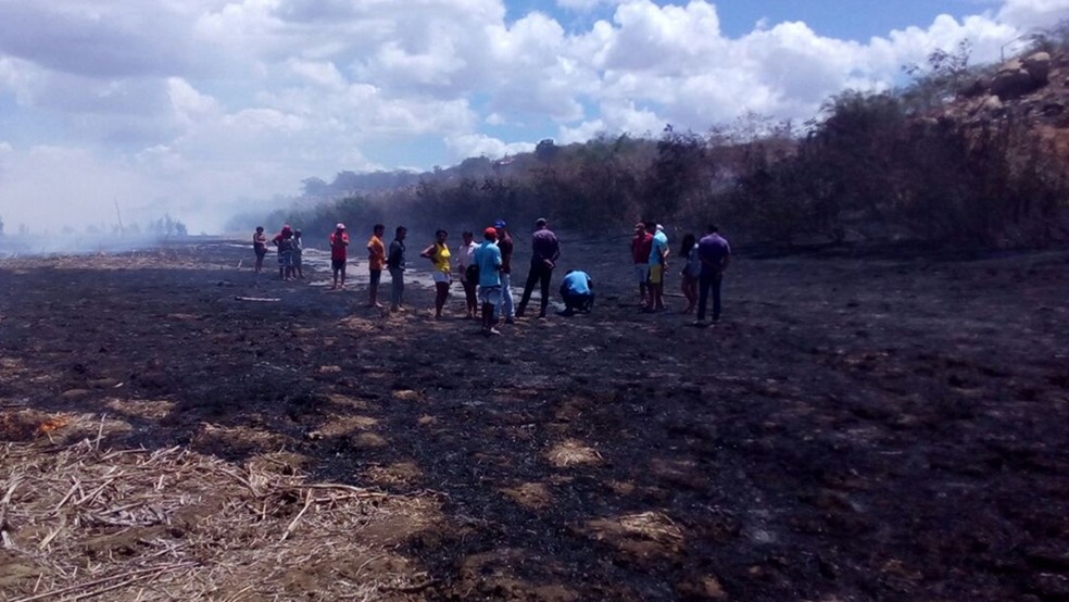 Moradores queimam vegetação para tentar facilitar passagem da água no Rio Paraíba (Foto: Felipe Valentin / TV Paraíba)