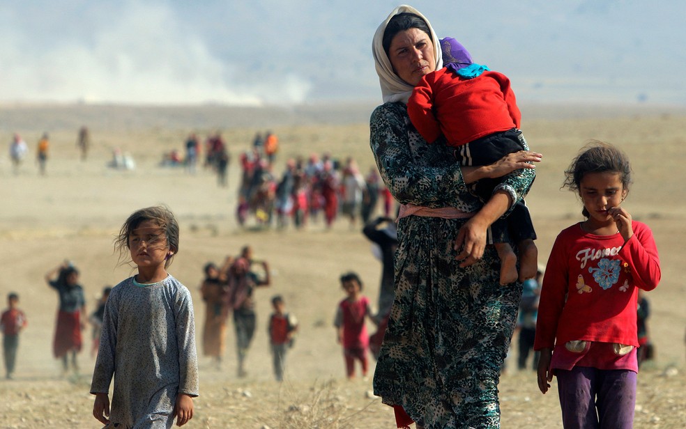 Imagem de 2014 mostra Yazidis caminhando em direção à Siria para escapar do Estado Islâmico (Foto: Rodi Said/Reuters)