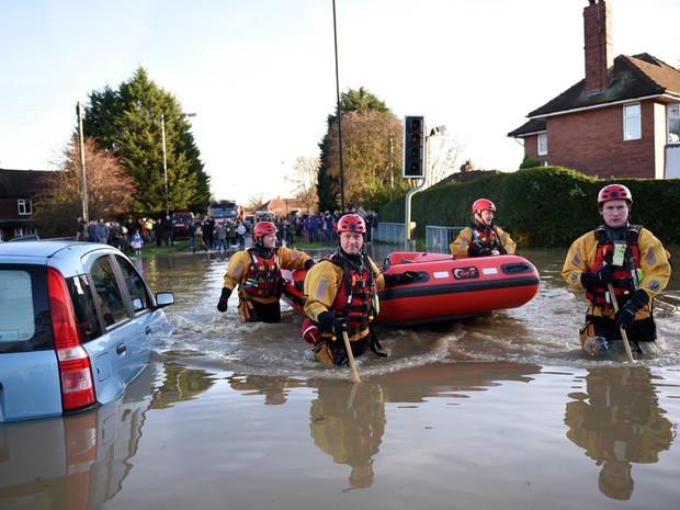   Funcionários do serviço de emergência trabalham para resgatar pessoas ilhadas por causa de inundação em York, no norte da Inglaterra, neste domingo (27)  (Foto: AFP Photo/Oli Scarff)