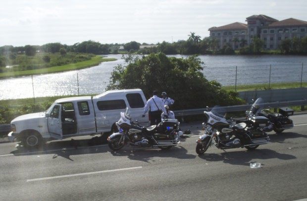 Policial é socorrido após o acidente neste domingo (9) (Foto: AFP)