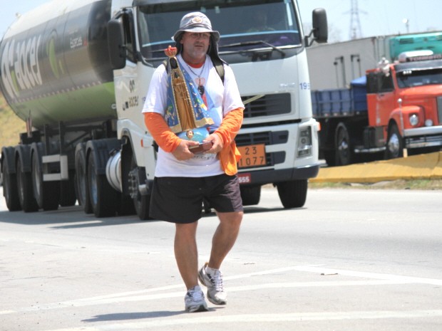 Romeiro carrega imagem de Nossa Senhora Aparecida, na Via Dutra, em direção ao Santuário Nacional. (Foto: Carlos Santos/G1)