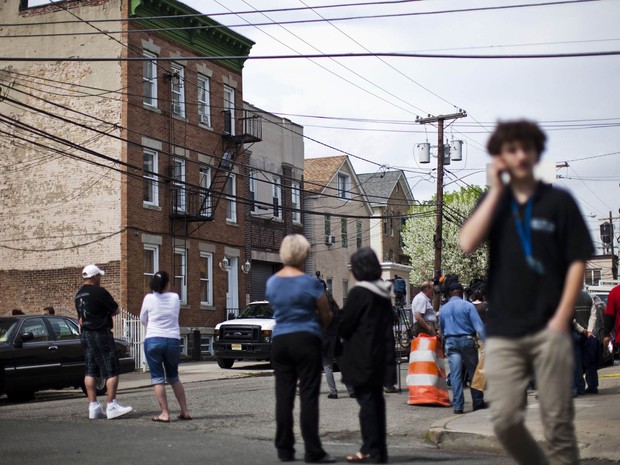 Vizinhos observam operação policial em torno do apartamento de Alina Tsarnaeva, em West New York, no estado de Nova Jersey. A mulher é irmã dos dois suspeitos pelo ataque a bombas em Boston (Foto: Eduardo Muñoz/Reuters)