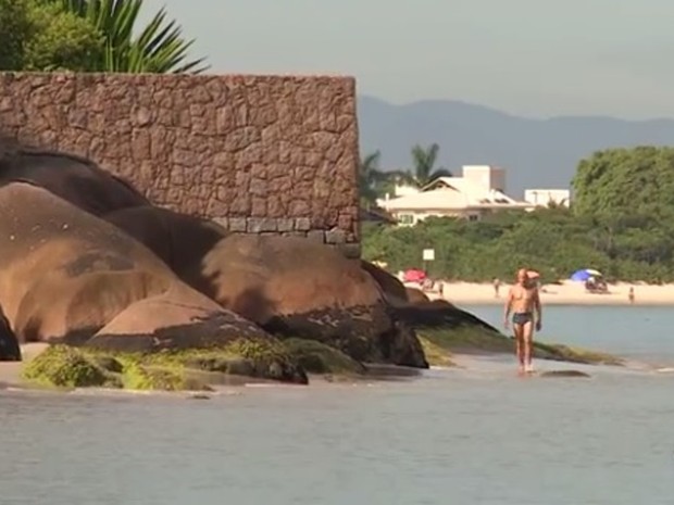 Em praias de Florianópolis, não é possível andar pela faixa de areiam por construções (Foto: Reprodução/RBS TV)
