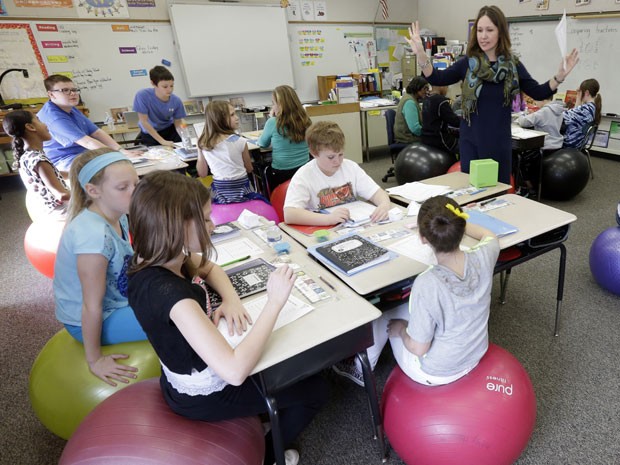 Estudantes do quinto ano têm aula sentados sobre bolas de ioga em escola norte-americana (Foto: Matt Rourke/AP)