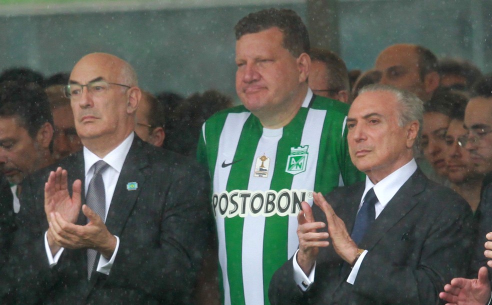 Luciano Buligon, com a camisa do Atlético Nacional, ao lado de Temer, na chegada dos corpos a Chapecó (Foto: Diego Vara/Reuters)