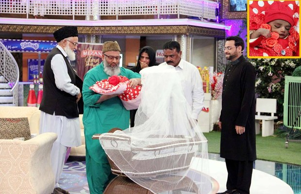 No último episódio do programa, transmitido no domingo, o apresentador Aamir Liaquat Hussain (à direita) dá uma menina a um casal (Foto: Reprodução Facebook/Amaan Ramazan Official)