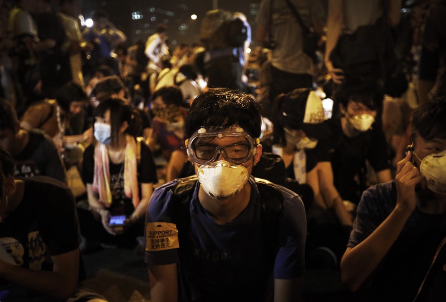 Student protesters sit on the main road outside the government complex where Hong Kong's Chief Executive Leung Chun-ying's office is located, Friday, Oct. 3, 2014 in Hong Kong. Hong Kong's embattled leader offered Thursday to hold talks between his govern