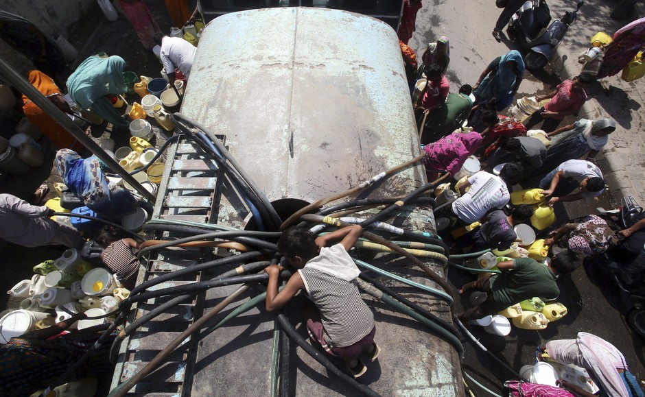 Pessoas em Nova Delhi correm para um tanque de água. A seca que assola a Índia tem afetado a agricultura do país