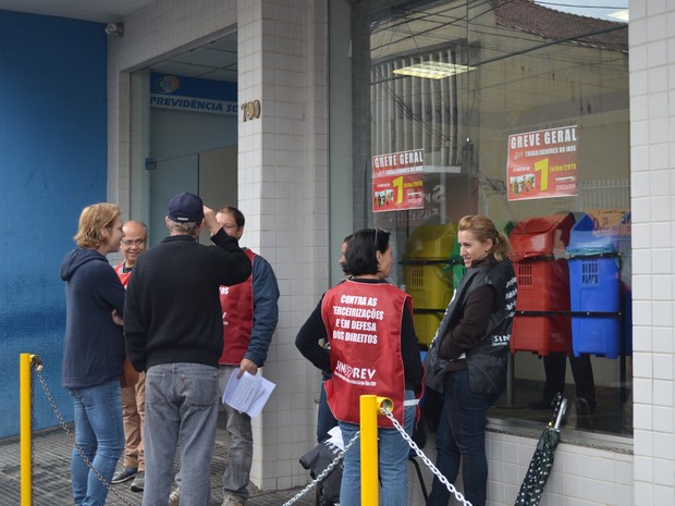 Funcionários do INSS estão na frente do prédio com panfletos (Foto: Bruna Sampaio/G1)