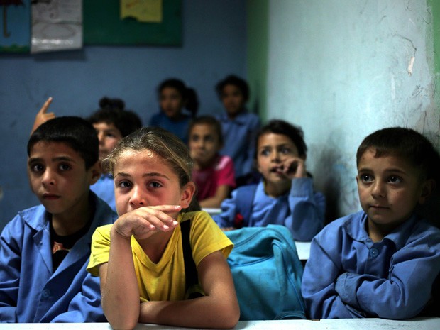 Estudantes sirios acompanham aula em escola para refugiados no Líbano (Foto: Hussein Malla/AP)