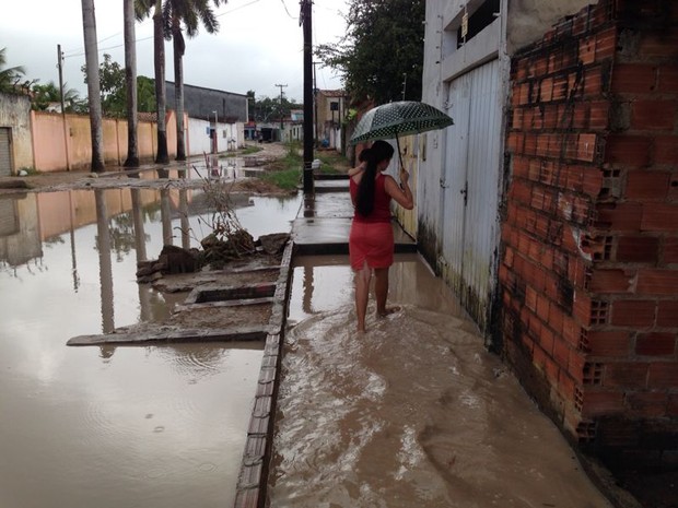 Moradora não deixa filho brincar no chão por conta da água suja. (Foto: Michelle Farias/G1)