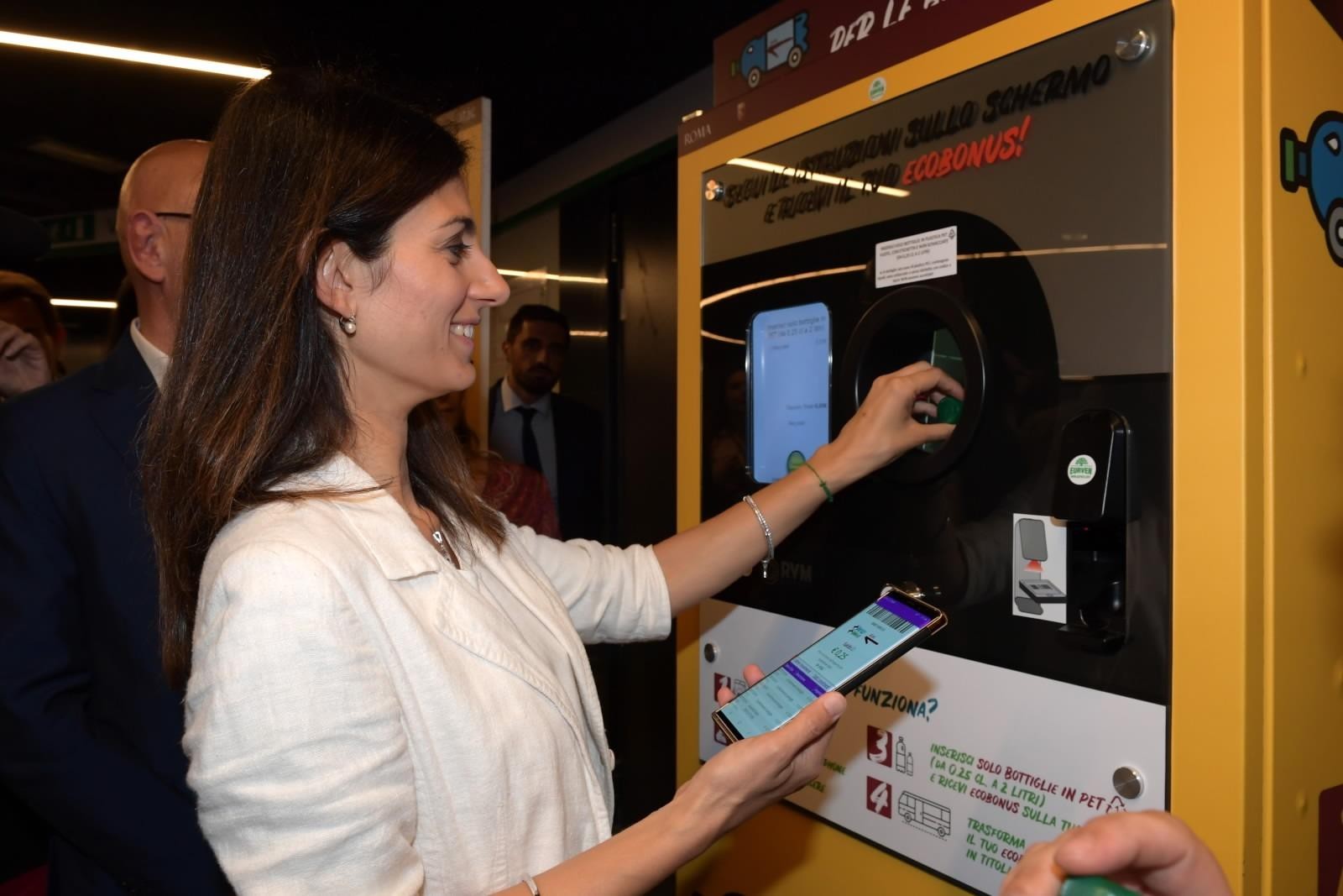 A prefeita de Roma, Virginia Raggi, demonstra funcionamento do programa que garante crédito na compra de bilhetes de metrô para quem recicla garrafas PET (Foto: Reprodução Facebook/Virginia Raggi)