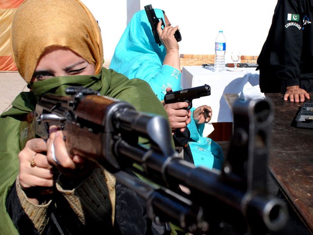 Professora maneja arma durante treinamento de segurança no Paquistão (Foto: Mohammad Sajjad/AP)