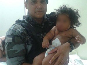 Tenente Ewerton Dias com um dos bebês nos braços, após o resgate (Foto: Marques Santos/Arquivo Pessoal) Tenente Ewerton Dias com um dos bebês nos braços, após o resgate (Foto: Marques Santos/Arquivo Pessoal)
