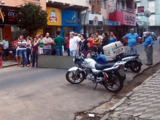 Rua alagada durante chuva foi interditada nesta quinta-feira (24) por comerciantes em Pouso Alegre, MG (Foto: Reprodução/ EPTV)