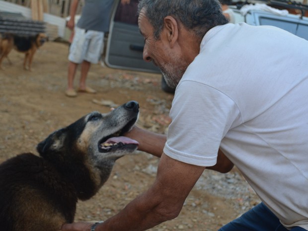 Antonio abraça cachorro que sobreviveu a parvovirose e agora vive em "vilarejo" em Mogi das Cruzes (Foto: Jamile Santana/ G1)