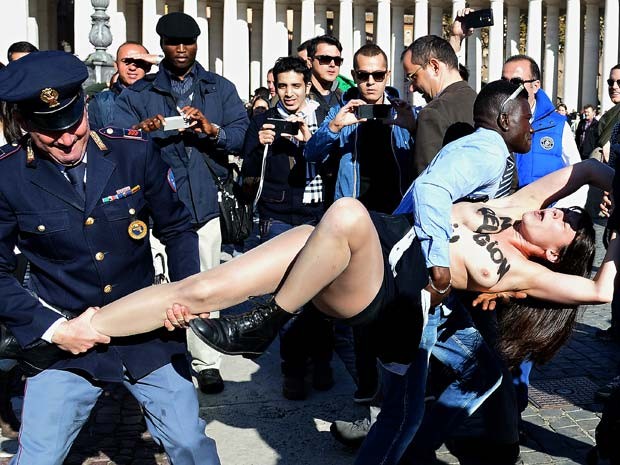 Ativista do Femen chama a atenção de tursitas no Vaticano e é levada por policiais (Foto: AFP PHOTO / ALBERTO PIZZOLI)