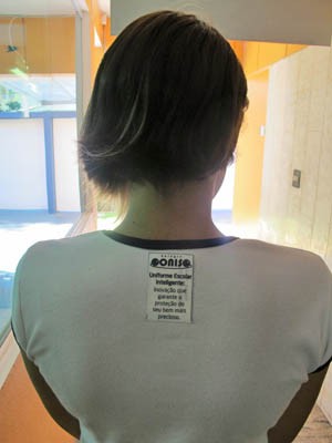 Aluna usando o uniforme com a etiqueta (Foto: Mariane Rossi/G1)
