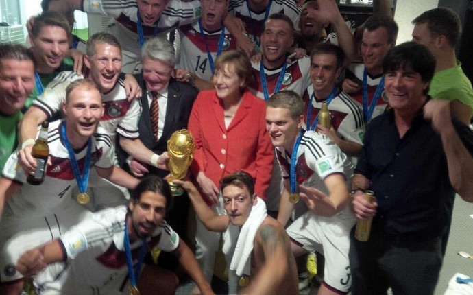 Jogadores da Alemanha comemoram vitória no vestiário com Angela Merkel (Foto: Reprodução/Twitter)