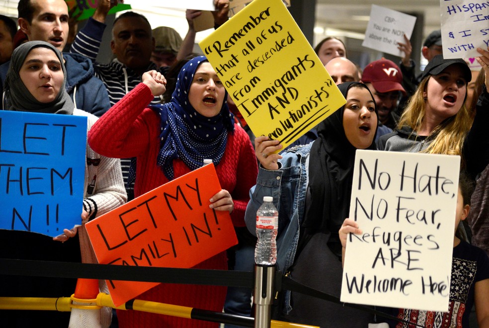 Manifestantes pró-imigração protestam contra medida de Trump no Aeroporto Internacional de Dulles, na Virgínia (Foto: REUTERS/Mike Theiler)