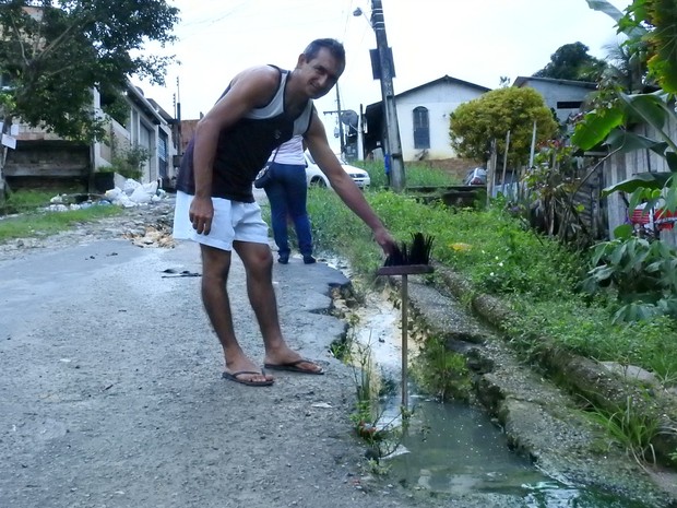 Comerciante Venilson Silva Tavares, de 38 anos,  mostrou a profundidade do buraco (Foto: Ive Rylo/G1AM)