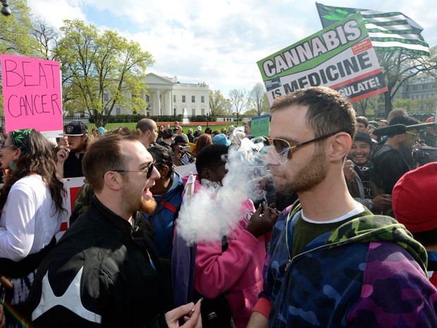 Defensores da reclassificação da maconha fumam em frente à Casa Branca, durante manifestação no sábado (2) (Foto: AFP Photo/Mike Theiler)