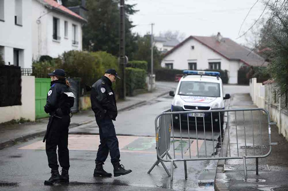 Polícia bloqueia entrada de rua que leva até a casa dos Troadec (Foto: Jean-Sebastien Evrard/AFP)