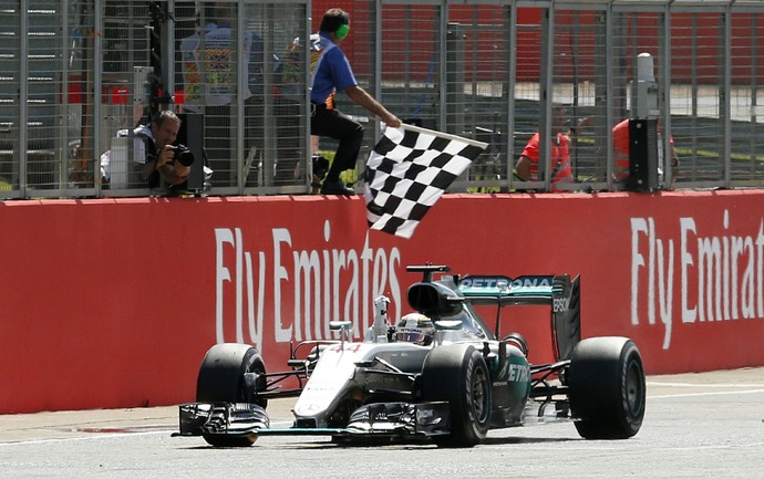 Lewis Hamilton recebe bandeira quadriculada para vencer GP da Inglaterra (Foto: Reuters)