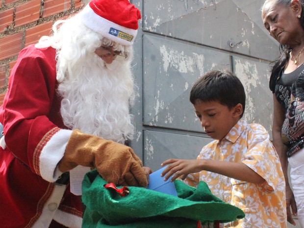 O pequeno Wanderson Pietro recebendo o documento do Papai Noel dos Correios (Foto: Fernando Brito/G1)