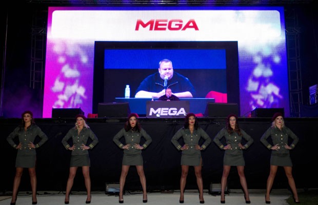 Fundador do Megaupload, Kim Dotcom aparece em uma tela grande durante o lançamento do site de compartilhamento de arquivos Mega em sua mansão em Auckland, na Nova Zelândia, neste domingo (20)  (Foto: AP)