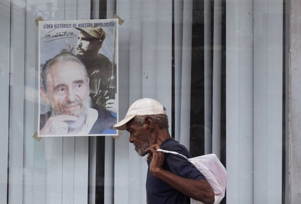 Cubano passa por cartaz com a imagem de Fidel Castro nesta segunda-feira (12) em Havana (Foto: AFP)