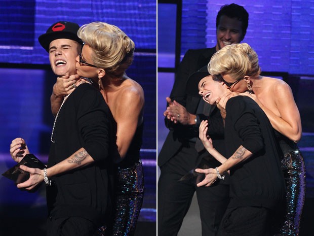 O cantor Justin Bieber ganha um beijo no pescoço dado por Jenny McCarthy, veterana da 'Playboy', durante um dos prêmios que recebeu no American Music Awards 2012 (Foto: Matt Sayles/Invision/AP)