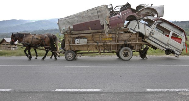 Em setembro de 2010, uma carroça foi fotografa supercarregada em Costesti, na Romênia. A carroça levava, inclusive, a carcaça de uma van. (Foto: Vadim Ghirda/AP)