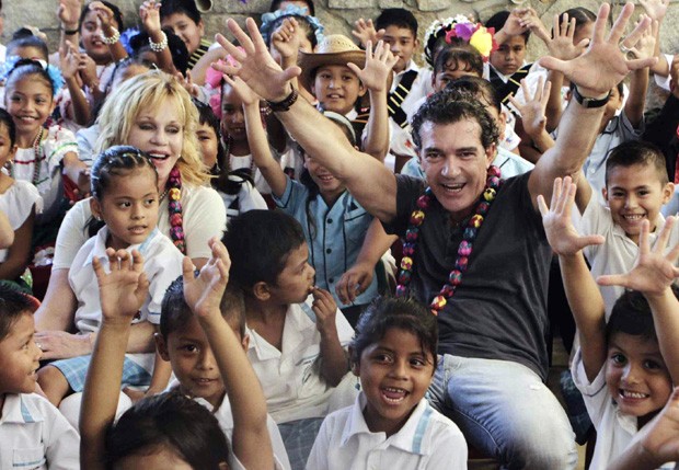 Melanie Griffith e Antonio Banderas cercados pelas crianças da escola (Foto: Grosby Group) Melanie Griffith e Antonio Banderas cercados pelas crianças da escola (Foto: Grosby Group)