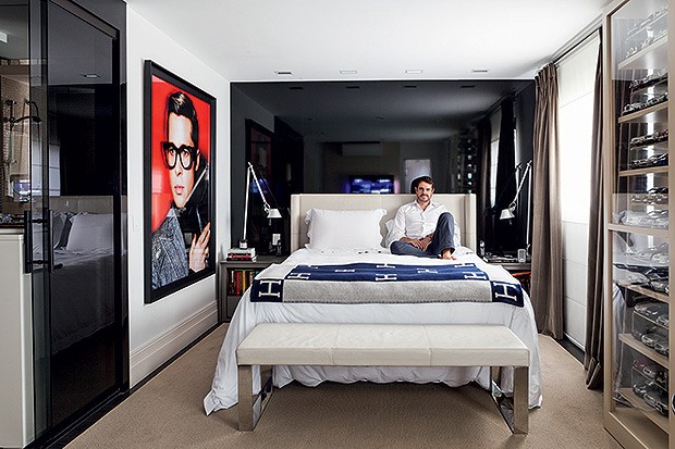 Suíte | Fabio Morozini aproveita o conforto de seu quarto. Peças da Trousseau e colcha Hermès vestem a cama com cabeceira de couro, da Artefacto. A parede de fundo foi revestida com madeira, laqueada de preto, pela Madero Marcenaria, que ainda produziu a  (Foto: Lufe Gomes/Casa e Jardim)