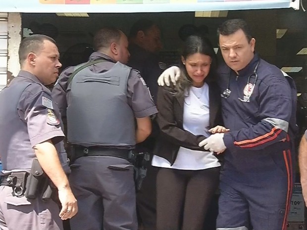 Mulher feita refém é retirada abalada de dentro da loja (Foto: Reprodução / TV TEM) Mulher feita refém é retirada abalada de dentro da loja (Foto: Reprodução / TV TEM)