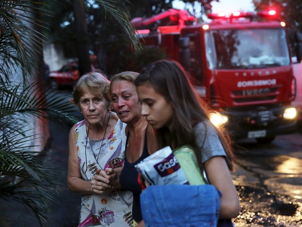 Márcia Carrara, de 64 anos, dona da casa onde um avião monomotor caiu, chora ao lado de um carro de bombeiros em São Paulo (Foto: Nacho Doce/Reuters)