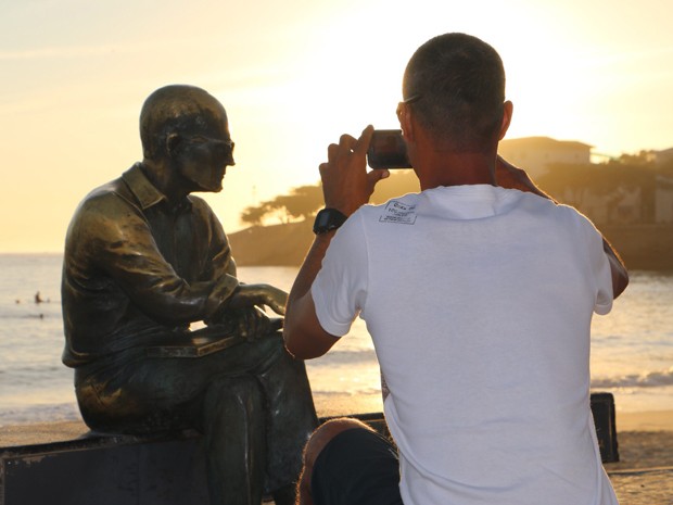 Carioca tira foto na estátua de Drummond, no Rio (Foto: José Raphael Berrêdo/G1)