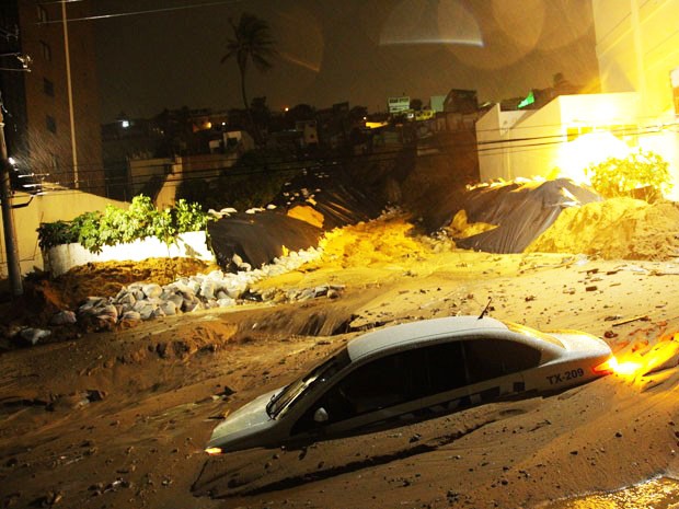 Foto feita na madrugada desta segunda-feira (23) mostra que táxi foi um dos carros que ficaram parcialmente soterrados após novo deslizamento em Mãe Luiza (Foto: Wallace Araújo/G1)
