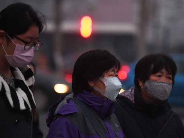 Mulheres usam máscaras nas ruas de Pequim (Foto: Greg Baker / AFP Photo)