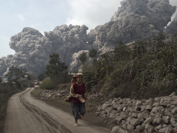 Habitante da vila Sukameriah corre após o vulcão Monte Sinabung entrar em erupção neste sábado (1), na ilha ocidental de Sumatra, na Indonésia (Foto: S Aditya/Reuters)